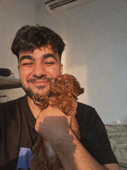 A Bricx designer holding a small brown puppy